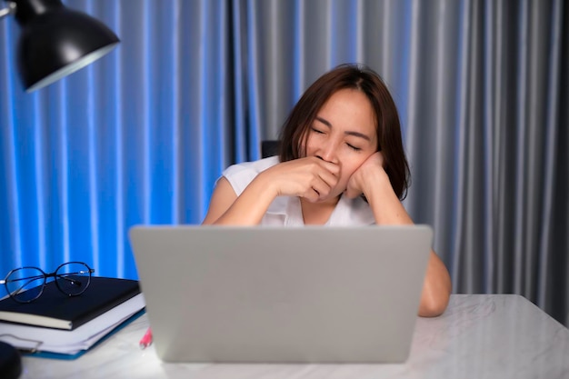 Bella donna asiatica che lavora a casa la notteUn sacco di lavoro dall'aziendaportare il lavoro a casaLavoro da casa concetto Stanco dal duro lavoro