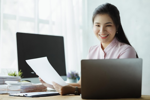 Bella donna asiatica che lavora con i computer nell'ufficio di una società di avvio è un impiegato delle finanze aziendali che lavora nel dipartimento finanziario Concetto di donne che lavorano in un'azienda
