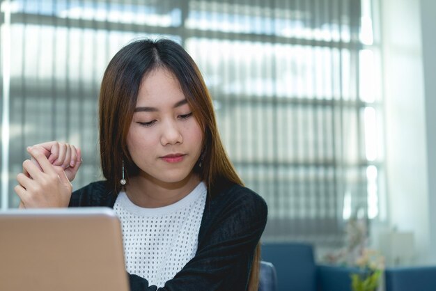 Bella donna asiatica che lavora in ufficio la sera Libro di scrittura del lavoratore della Tailandia nell'azienda