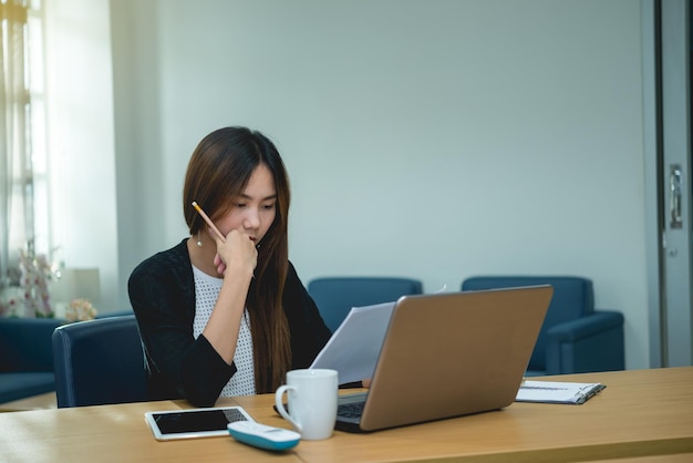 Bella donna asiatica che lavora in ufficio la seraThailandia lavoratore stress dal lavoroPensa all'idea per un nuovo prodotto