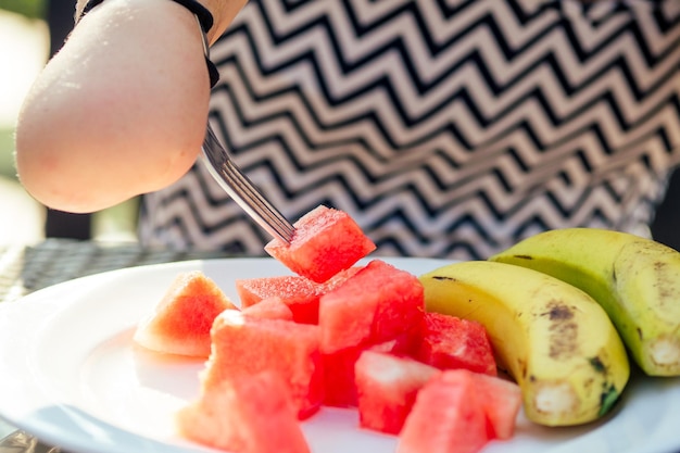 Bella donna asiatica che mangia colazione al resort tropicale beve una tazza di tè o caffè