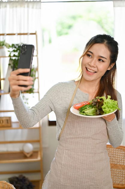 Bella donna asiatica che prende selfie di se stessa e della sua insalata fatta in casa Stile di vita sano