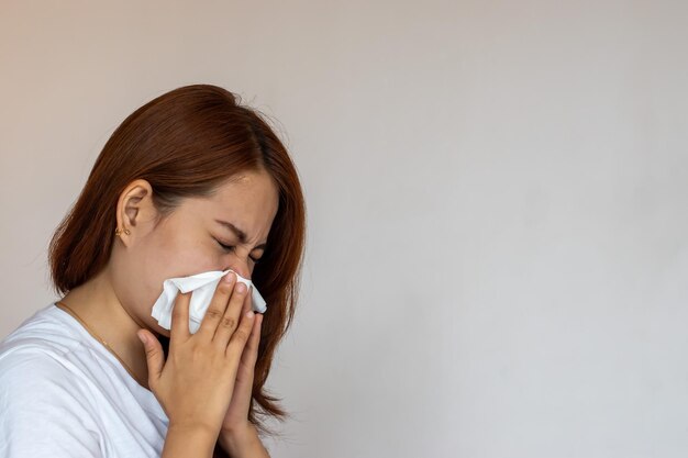 Bella donna asiatica che soffre di naso che scorre o di blocco nasale Sinusite da raffreddore comune o influenza paziente con rinite