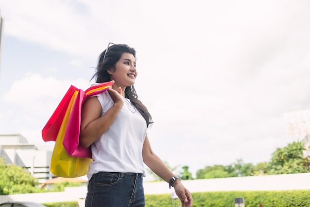 bella donna asiatica che tiene i sacchetti della spesa colorati in città