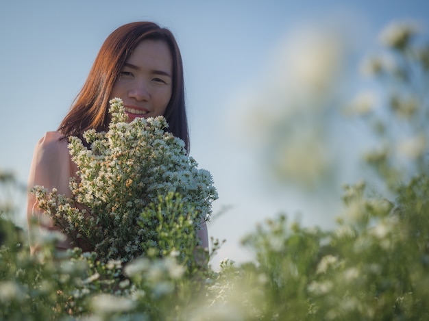 Bella donna asiatica circondata dai fiori