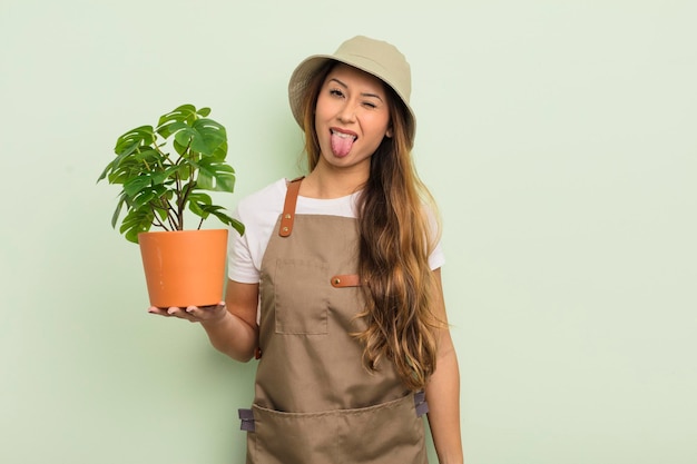 Bella donna asiatica con atteggiamento allegro e ribelle che scherza e tira fuori la lingua concetto di giardiniere