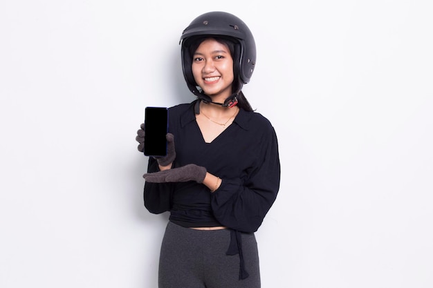 bella donna asiatica con un casco da motociclista che dimostra cellulare cellulare isolato su bianco