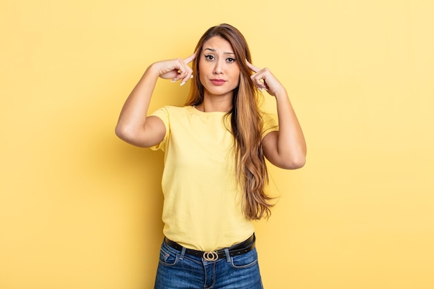 Bella donna asiatica con uno sguardo serio e concentrato che fa brainstorming e pensa a un problema impegnativo