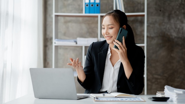 Bella donna asiatica dirigenti dirigenti aziendali dirigenti marketing stanno parlando al telefono con i clienti per contattare l'azienda per il marketing Concetto di gestione del marketing