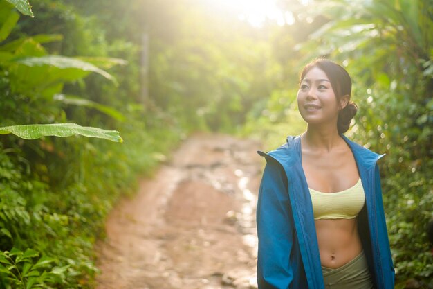 Bella donna asiatica in abbigliamento sportivo trekking sul sentiero di montagna Concetto di viaggio ed ecoturismo