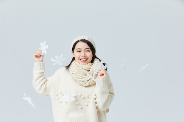 Bella donna asiatica in un maglione e un cappello bianchi