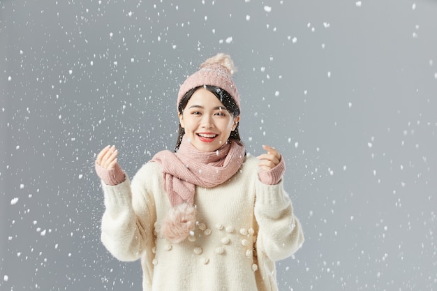 Bella donna asiatica in un maglione e un cappello bianchi