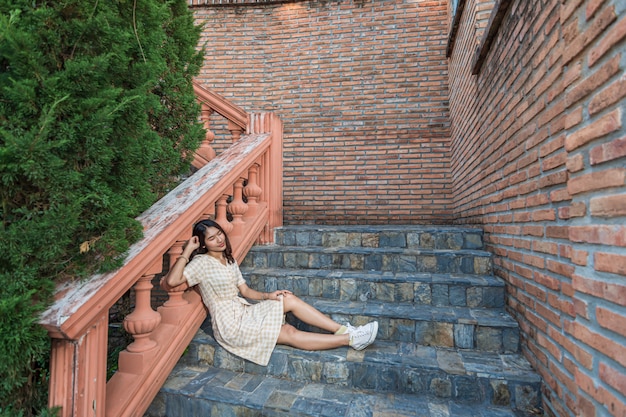 bella donna asiatica in vista di una scala in pietra e un muro di mattoni