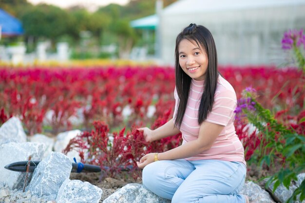 Bella donna asiatica nel giardino di fiori con sfondo naturale