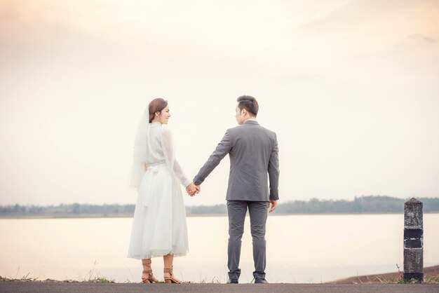 Bella donna asiatica vestita da sposa su sfondo bianco