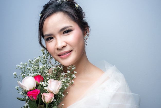 Bella donna asiatica vestita da sposa su sfondo bianco