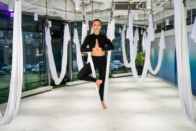 Bella donna atletica allenamento in palestra, facendo esercizi di stretching prima dell'allenamento