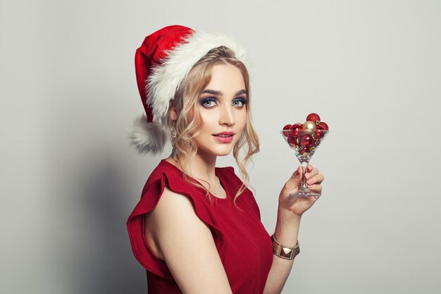 Bella donna Babbo Natale con un bicchiere di vino con la decorazione di Natale su sfondo bianco
