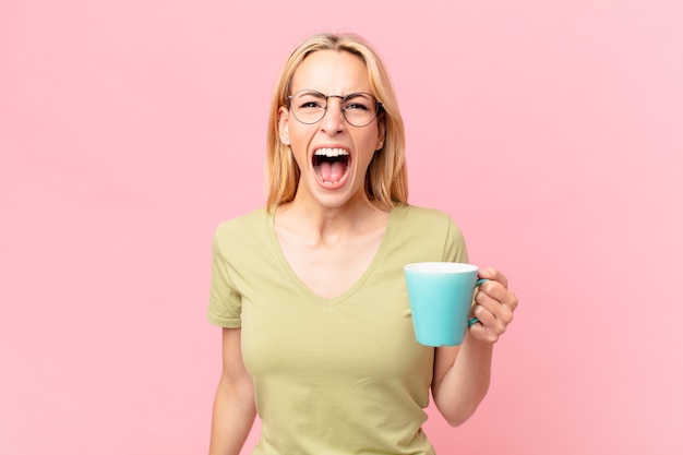 Bella donna bionda che beve un caffè