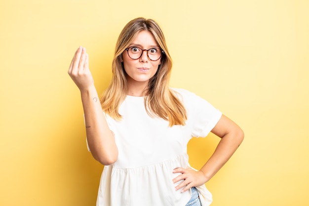 Bella donna bionda che fa un gesto di denaro o di denaro, dicendoti di pagare i tuoi debiti!