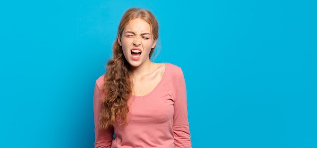 Bella donna bionda che grida in modo aggressivo, sembra molto arrabbiata, frustrata, oltraggiata o infastidita, grida di no