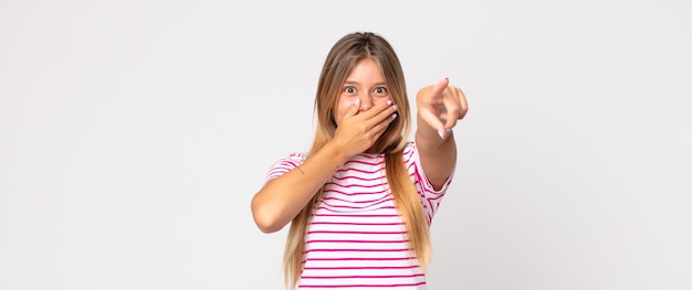 Bella donna bionda che ride di te, indica la telecamera e ti prende in giro o ti prende in giro