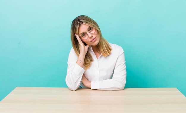 Bella donna bionda che si sente annoiata, frustrata e assonnata dopo un noioso concetto di lavoro e scrivania