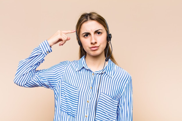 Bella donna bionda che si sente confusa e perplessa, dimostrando che sei pazzo, pazzo o fuori di testa