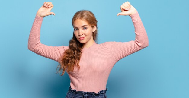 Bella donna bionda che si sente orgogliosa, arrogante e sicura di sé, che sembra soddisfatta e di successo, indicando se stessa