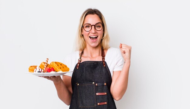 Bella donna bionda che si sente scioccata e ride e celebra il concetto di cialde di successo