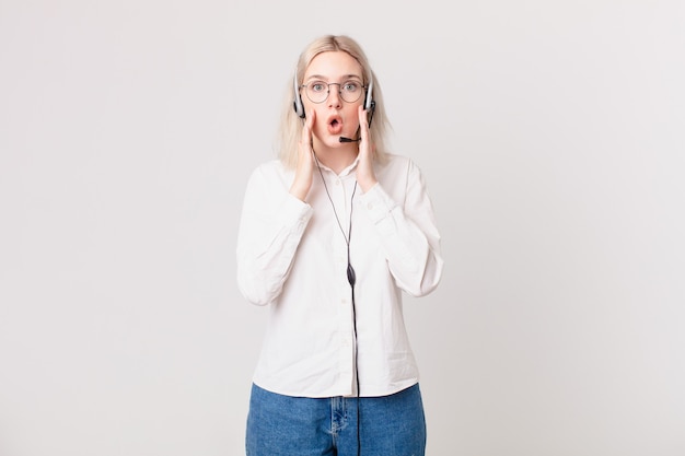 Bella donna bionda che si sente scioccata e spaventata dal concetto di telemarketing