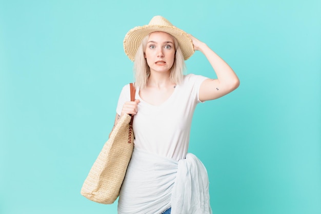 Bella donna bionda che si sente stressata, ansiosa o spaventata, con le mani sulla testa. concetto di estate