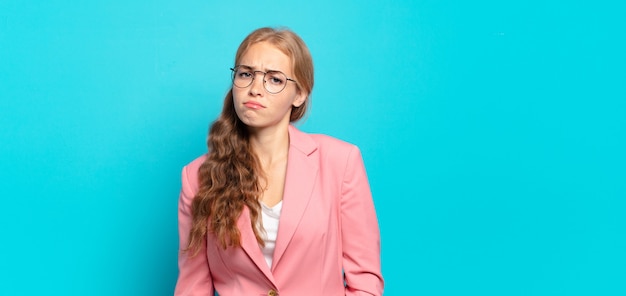 Bella donna bionda che si sente triste e piagnucolona con uno sguardo infelice, piange con un atteggiamento negativo e frustrato