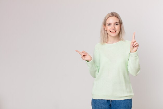 Bella donna bionda che sorride e sembra amichevole, mostrando il numero uno