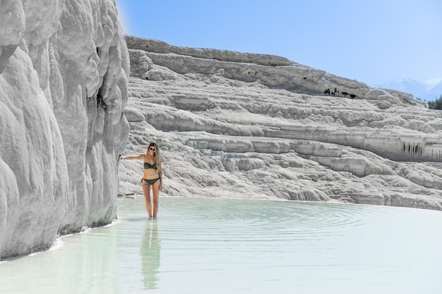 Bella donna bionda con costumi da bagno in travertino naturale piscine e terrazze a Pamukkale Turchia