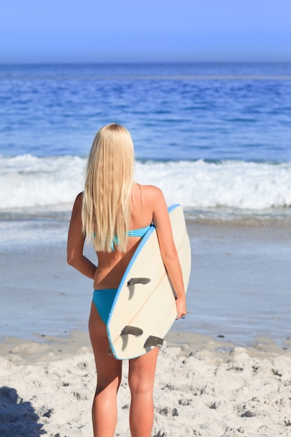 Bella donna bionda con la sua tavola da surf