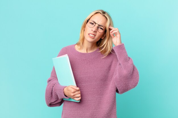 Bella donna bionda con libri che studiano