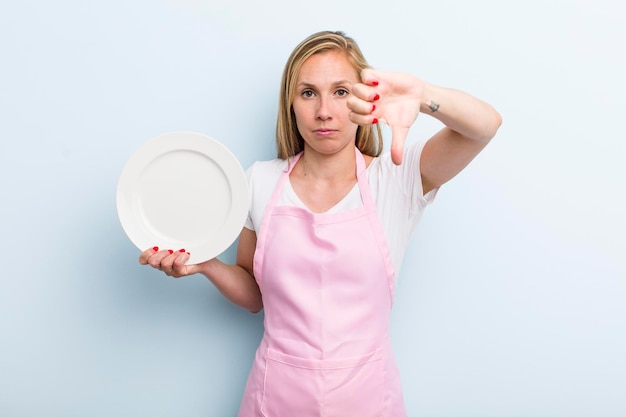 Bella donna bionda con un concetto di chef piatto vuoto