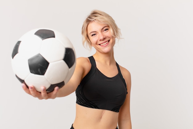 Bella donna bionda con un pallone da calcio