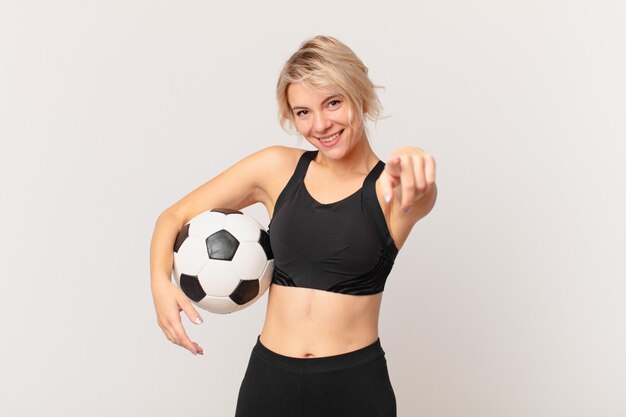 Bella donna bionda con un pallone da calcio