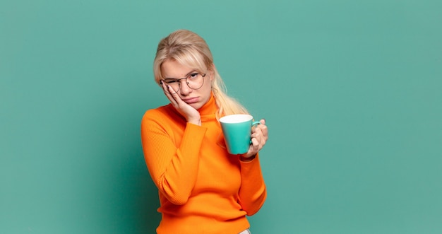 Bella donna bionda con una tazza di caffè o tè