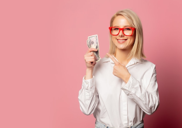 Bella donna bionda in bicchieri con dollari in contanti