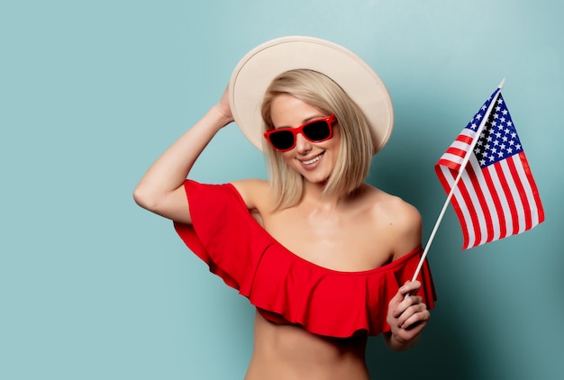 Bella donna bionda in bikini con bandiera USA