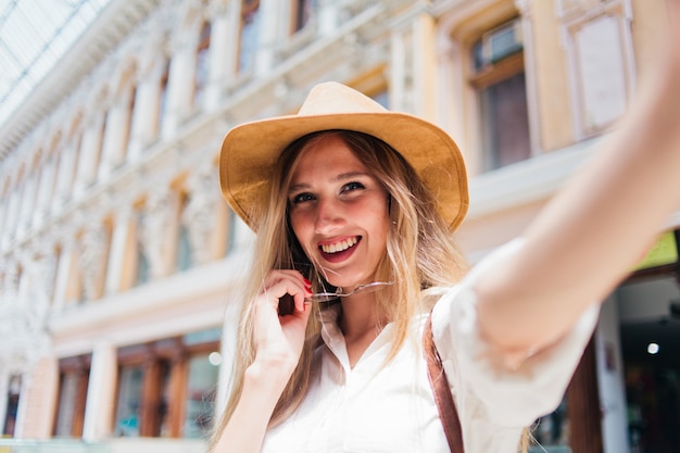 Bella donna bionda in cappello di feltro e occhiali