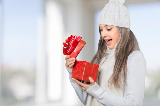 Bella donna bionda in cappello invernale con regalo