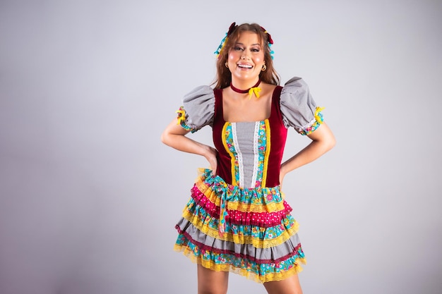 Bella donna brasiliana con abiti di campagna Festa de Sao Joao Festa Junina che fa una posa divertente