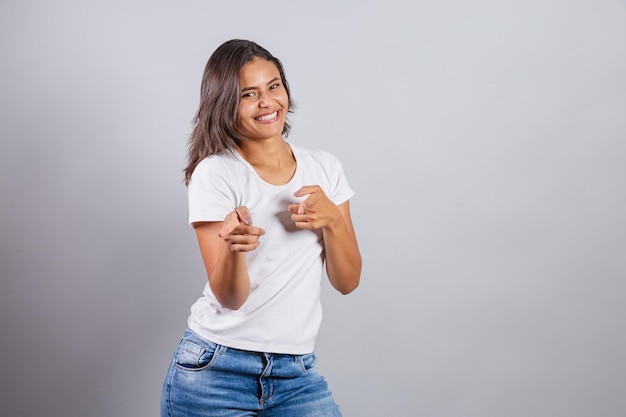 Bella donna brasiliana denim e bianco che punta alla fotocamera scegliendo la tua scelta