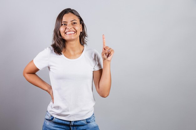 Bella donna brasiliana denim e bianco con un dito indice di creatività idea alzato