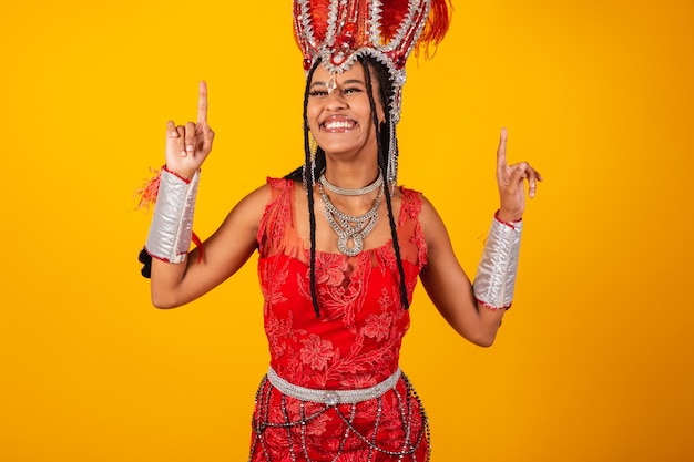 Bella donna brasiliana nera con vestiti rossi di carnevale che ballano festa