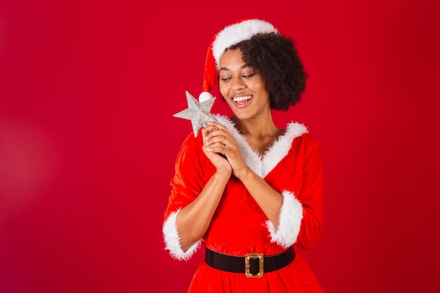 Bella donna brasiliana nera vestita da babbo natale mama claus gratitudine con la stella di natale